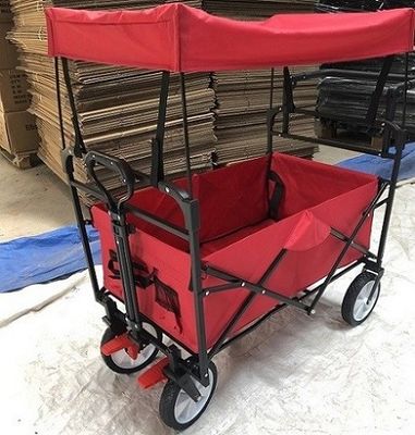 I carretti pieghevoli del carretto pieghevole rosso del vagone con le ruote coprono la maniglia di spinta